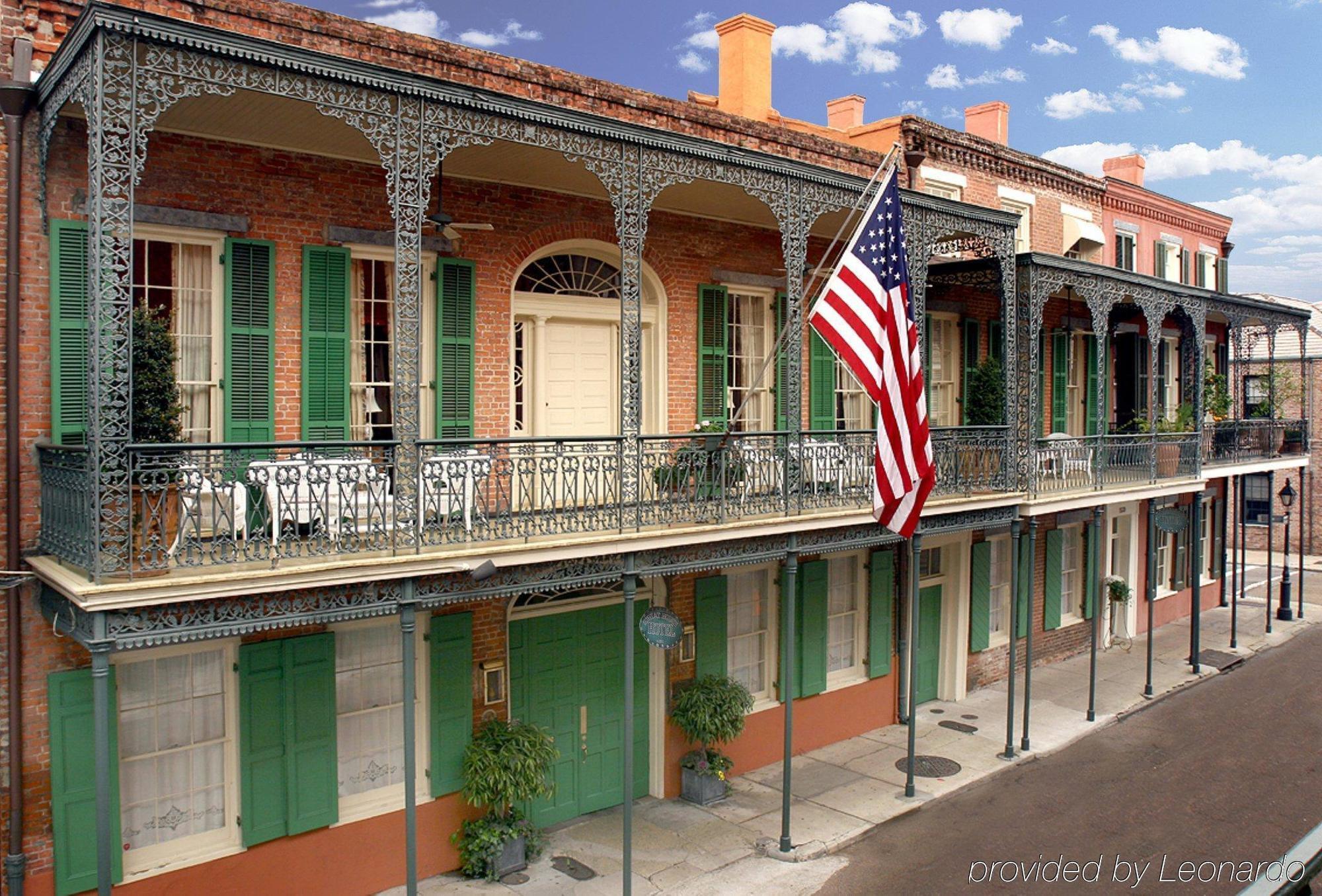 A historic brick building with a balcony and an American flag
